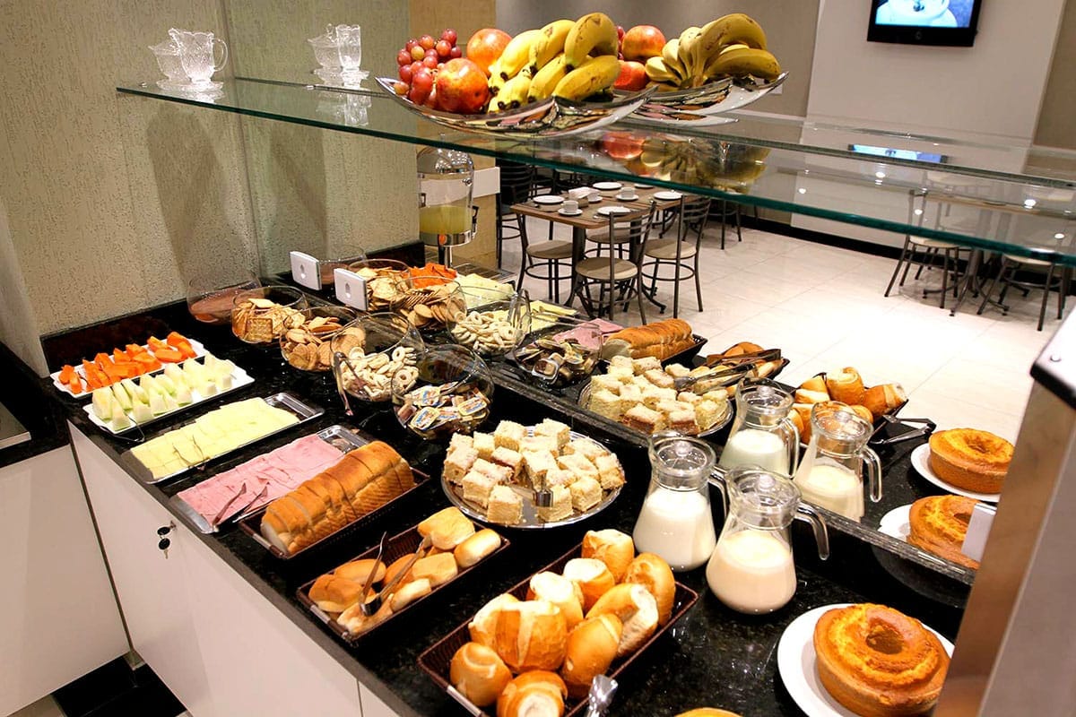 Mesa farta do café da manhã do Hotel Curitibano com frutas, pães e frios
